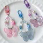 Bag charm kupu-kupu akrilik pastel warna pink biru ungu dengan efek hologram dan manik-manik lucu untuk aksesori tas